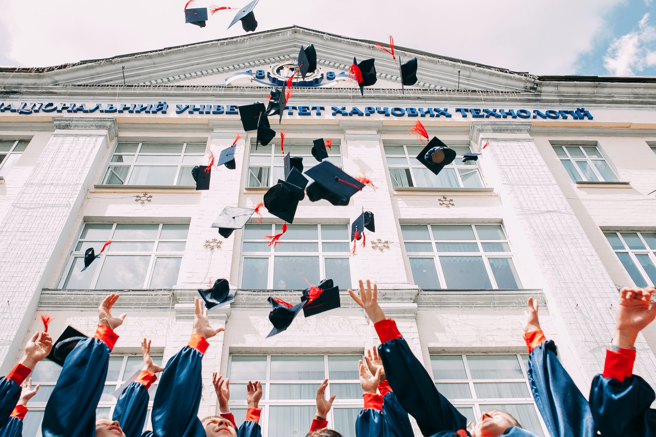 A group of students throwing their graduation caps into the air.